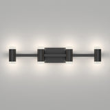 A modern wall-mounted light fixture with a matte black finish, featuring four evenly spaced cylindrical lights, each with frosted ends, set against a plain light gray background.