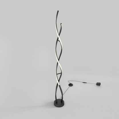 Artika Swirl modern LED floor lamp with twisted black and white strips on round base, plugged in against a plain background.