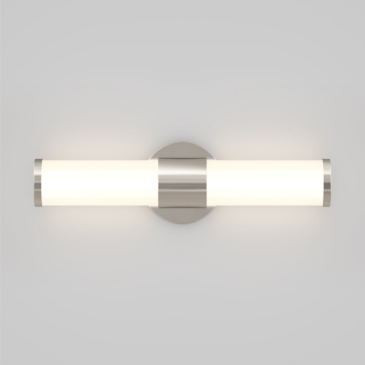 A modern wall-mounted light fixture with a cylindrical frosted glass shade and metallic accents, emitting a soft, even glow, attached to a round base on a light gray wall.