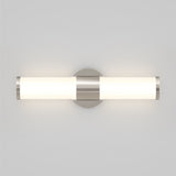 A modern wall-mounted light fixture with a cylindrical frosted glass shade and metallic accents, emitting a soft, even glow, attached to a round base on a light gray wall.