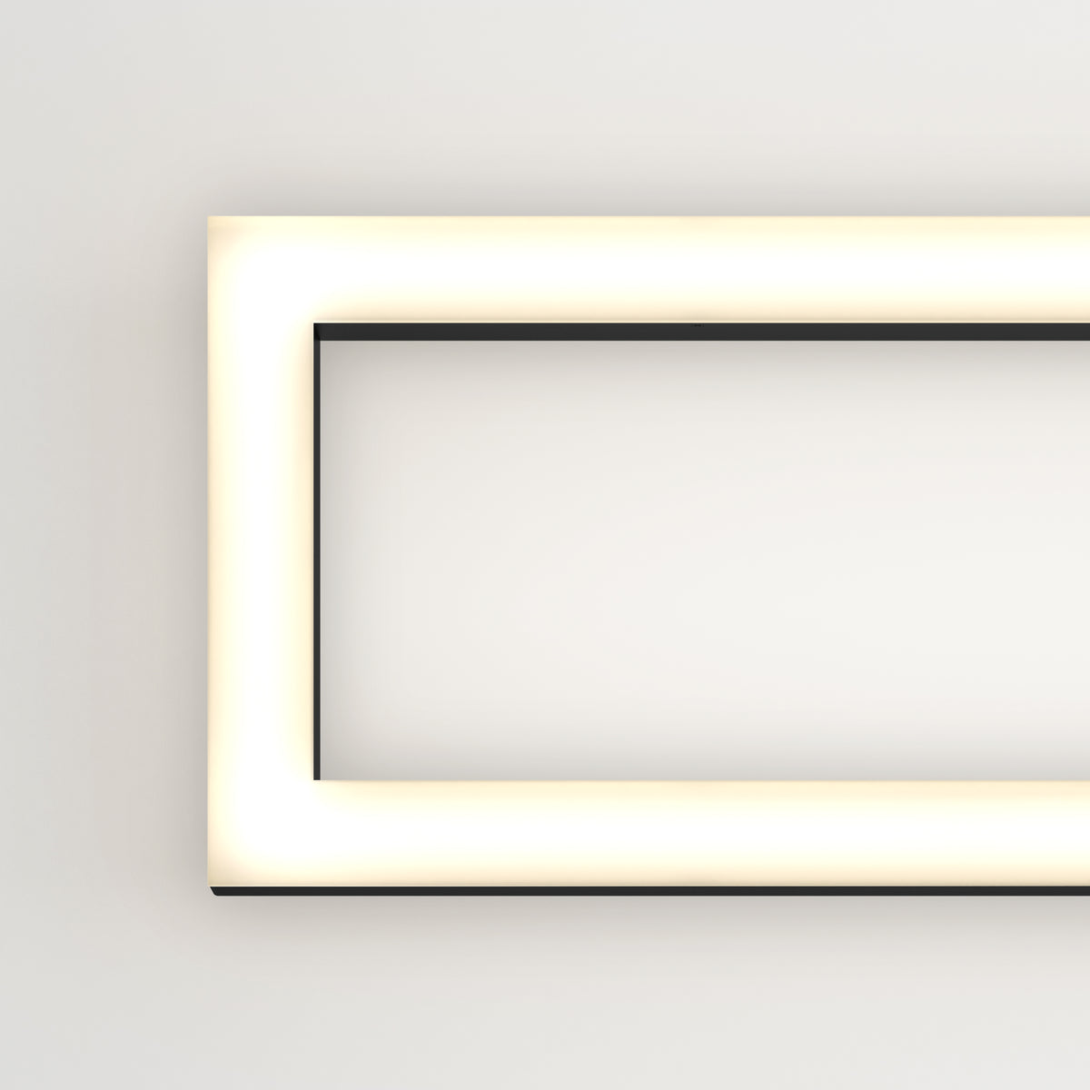 A glowing rectangular light fixture with rounded corners is mounted on a plain white wall, emitting a soft, even light. Only the left half of the fixture is visible in the image.