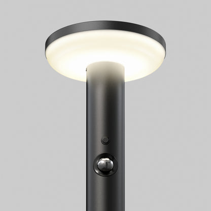 The Artika Urbia Solar LED Bollard features a black pole, round light, motion sensor button, and is shown on a plain gray background.