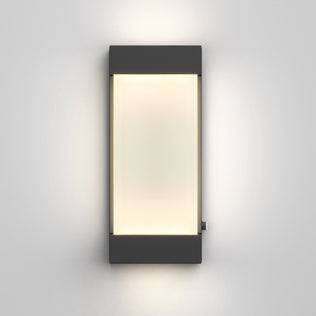 The Artika Glacier indoor-outdoor LED wall light features a black frame and frosted center panel, casting a soft, diffused glow on a gray wall.