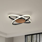 Modern ceiling light fixture with two intersecting black rings featuring integrated LED lights and a central wooden accent, mounted on a white ceiling near a window with black blinds.