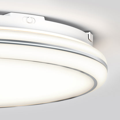 Close-up view of a modern, circular white ceiling light fixture mounted on a white ceiling, featuring a sleek design with soft, diffused illumination.