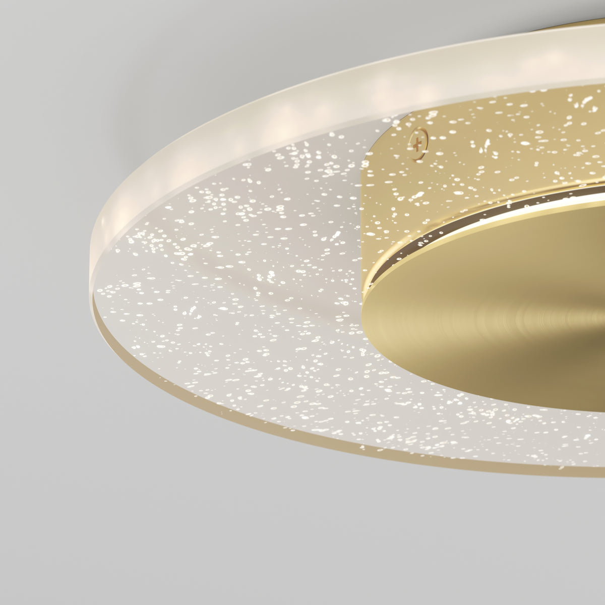 Close-up of the Artika Essence Disk LED flush mount, a modern ceiling fixture with a circular gold base and a translucent, star-speckled ring, set against a plain light gray wall.
