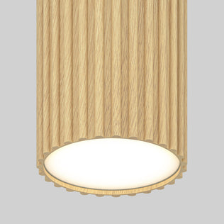 The Artika Groove LED modern pendant light 3 CCT features a cylindrical textured wood finish with vertical grooves, casting bright white light from the base—ideal for kitchen islands against a plain light gray backdrop.