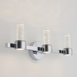 A modern wall sconce with three cylindrical glass light fixtures featuring a sparkling, bubble-like design, all mounted on a chrome base against a white wall.
