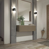 A modern hallway with a floating beige console, a large mirror, wall sconces, a green vase with foliage, wooden floors, and an umbrella in the corner. Light streams in, creating a bright, clean atmosphere.