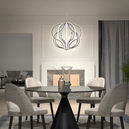 A modern dining room features a round black table, four gray upholstered chairs, a decorative centerpiece, and the Artika Meridian LED pendant light. In the background, a lit fireplace and cozy living area can be seen.