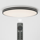 A round, modern ceiling light is mounted on a white ceiling, with a remote control positioned below it. A wireless signal icon is shown between the light and the remote, indicating remote operation.