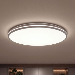 Artika’s GLOW 30 in. LED Flush Mount Ceiling Light 5 CCT with remote shines above shelves and plants, adding modern flair.