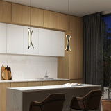 Modern kitchen with wood and white cabinetry, marble backsplash and countertop, two pendant lights, a sink, dark curtains, and two brown barstools at a breakfast island. A book and cutting boards sit on the counter.
