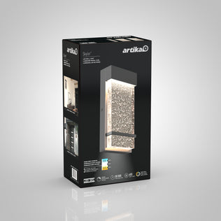 A black and gray Artika retail box for the Skyler indoor-outdoor LED wall light, showing the modern rectangular fixture with textured illuminated panel, plus product details and specs on the packaging.