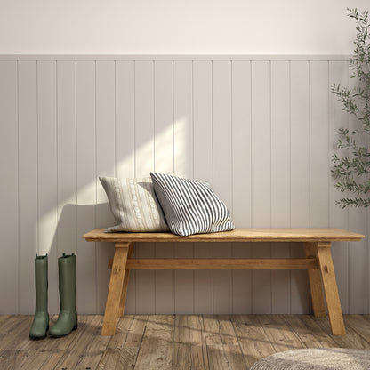 Wooden bench with pillows beside green boots, set by Artika AXEN Shilap Ready-to-Paint MDF Wall Panels and a potted plant.