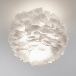 The Artika Plume LED flush mount light features a white, feathered design that softly diffuses light through its layered feathers, evoking a cloud-like ambiance in any room.