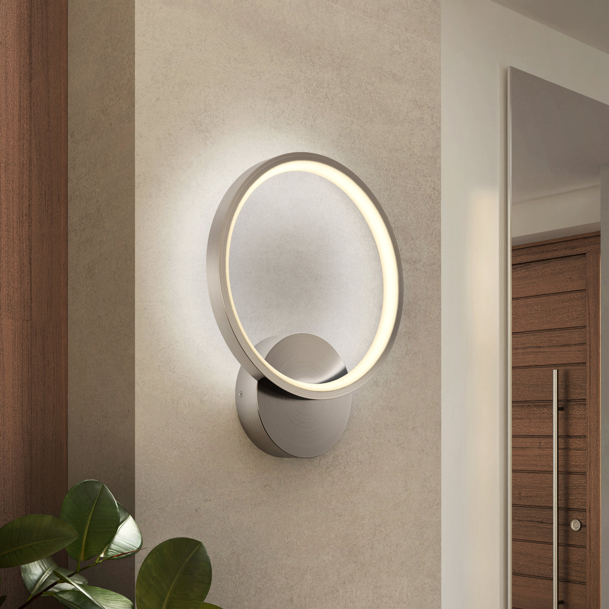 The Artika Solis modern LED indoor-outdoor wall light 5 CCT is mounted on a light wall near a wooden door and green plant, providing accent lighting and elevating the contemporary style of your space.