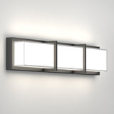 A modern wall-mounted light fixture with three rectangular frosted glass panels, each framed in black metal, mounted on a sleek horizontal base against a plain white wall.