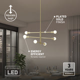 Modern chandelier with plated gold finish and eight LED bulbs hangs in a stylish dining room. Features noted include adjustable height, energy efficiency (no bulbs required), and a 3-year warranty. Dining table and window visible.