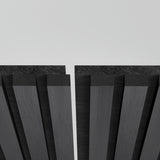 Close-up of two parallel black acoustic panels with vertical grooves, separated by a narrow gap, against a plain light gray background.