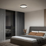 Modern bedroom with a gray upholstered bed, brown and white bedding, a bedside table with dried flowers, floor-to-ceiling curtains, glass doors, and a round ceiling light. Neutral tones and minimalistic decor.
