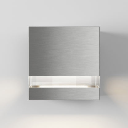 The Artika-CAN-dev Valor Square LED indoor/outdoor wall light features a modern brushed metal design with a horizontal frosted strip emitting soft white light, mounted on a plain light gray wall.