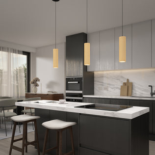 Modern kitchen with dark wood cabinets, white marble island, two cushioned stools, built-in oven, and a large window with sheer curtains. Artika's Groove LED modern pendant light 3 CCT hangs over the island; decorative items adorn counter and sideboard.