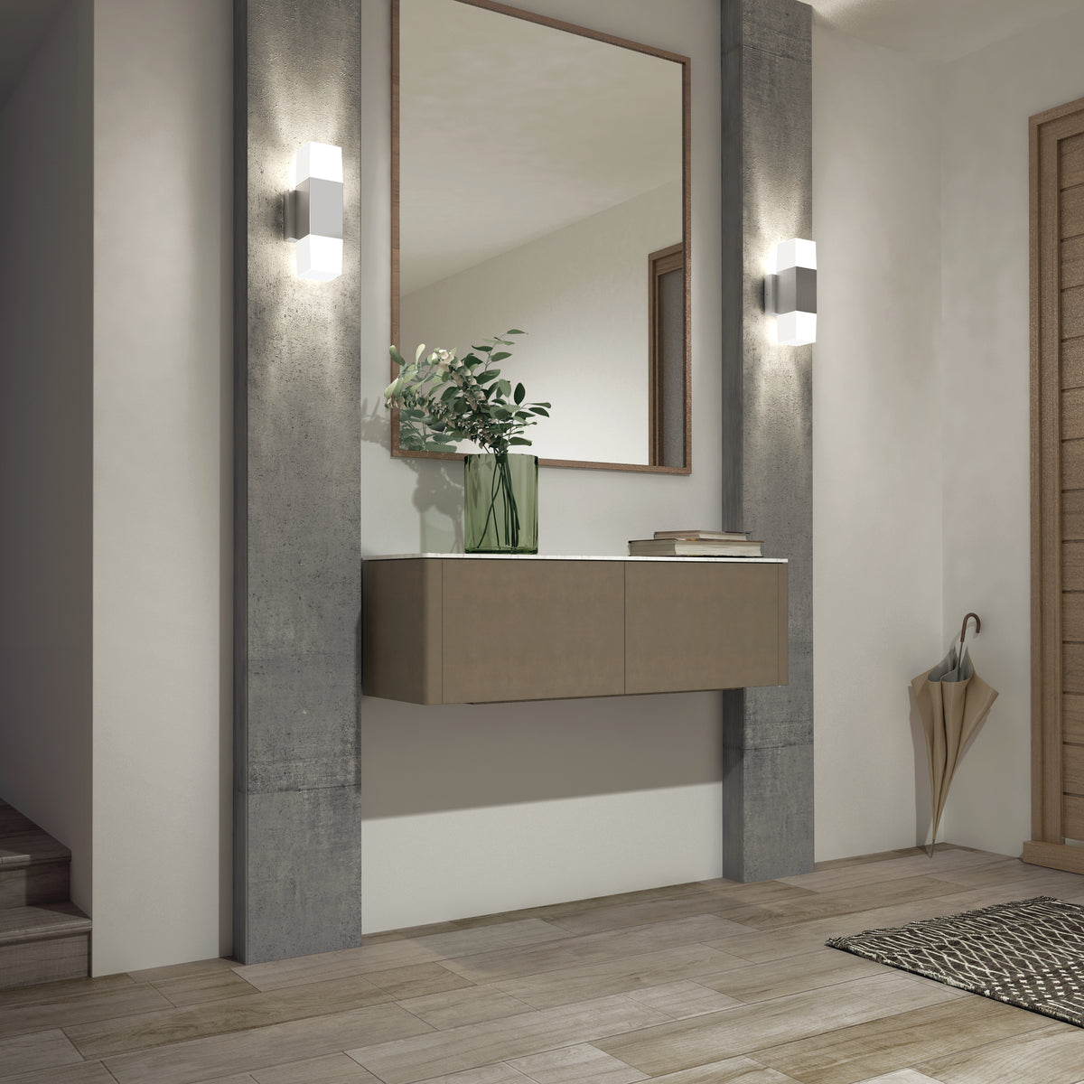 Modern entryway with light wood flooring, a floating console topped with a green vase of leafy branches, a large mirror, woven mat, umbrella stand, and two Artika Lennox indoor-outdoor LED wall lights (3 CCT) in matte black beside the stairs.