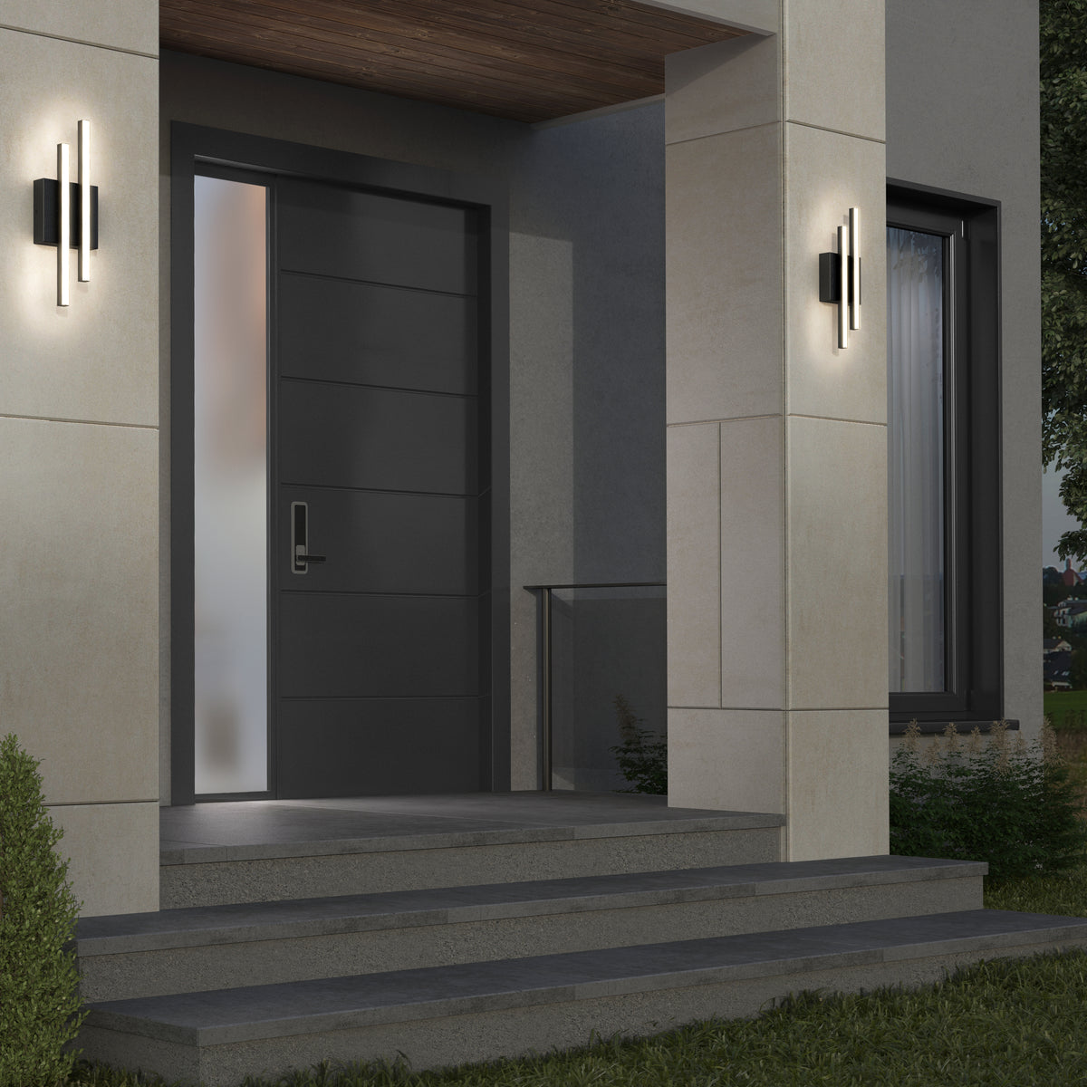 A modern house entrance with a dark gray front door, frosted glass side panel, concrete steps, wall-mounted lights, and a large window to the right. The entryway is surrounded by beige walls and greenery.