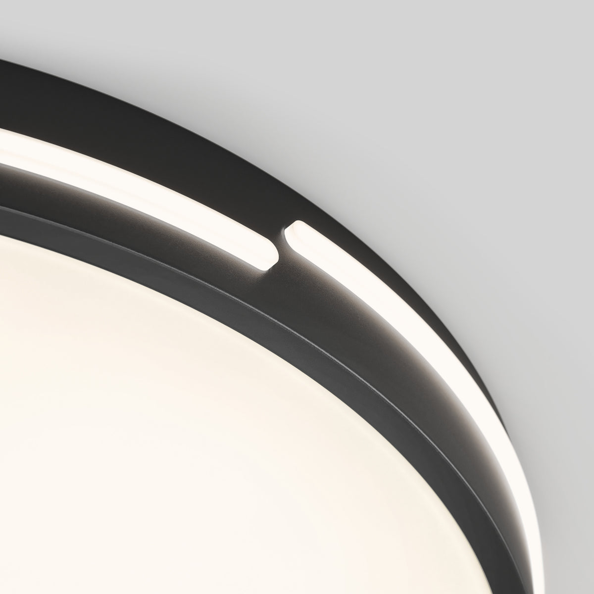 Close-up of the Artika Delray 15.7 in. LED modern flush mount light, featuring a dark frame and integrated LED strip with 5 CCT, emitting soft white light in a minimalistic, contemporary design against a light gray background.