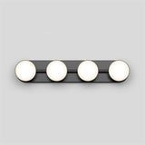 A horizontal black light fixture with four evenly spaced round white bulbs mounted on a light gray wall.