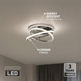 Modern ceiling light fixture with intertwined LED loops and a chrome finish, labeled as energy efficient (no bulbs required), with a 3-year warranty and integrated LED, installed in a contemporary room.