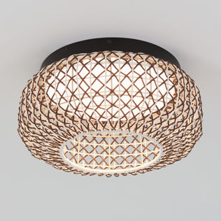 The Artika Benson 15 in. LED flush mount light features a round, woven rattan shade with a visible inner white diffuser and lattice pattern, mounted flush to a plain white ceiling. Offers 5 CCT options for customizable lighting.
