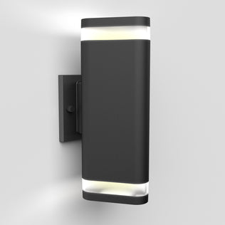 The Artika Trygon indoor-outdoor wall light is a modern, rectangular black sconce with frosted diffusers on both ends, mounted on a white wall and emitting light from the top and bottom.