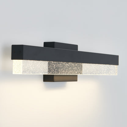 The Artika Bubble Bar LED bathroom vanity light features a modern wall-mounted design with a black rectangular frame and frosted glass panel, emitting a soft, even glow against a white wall.