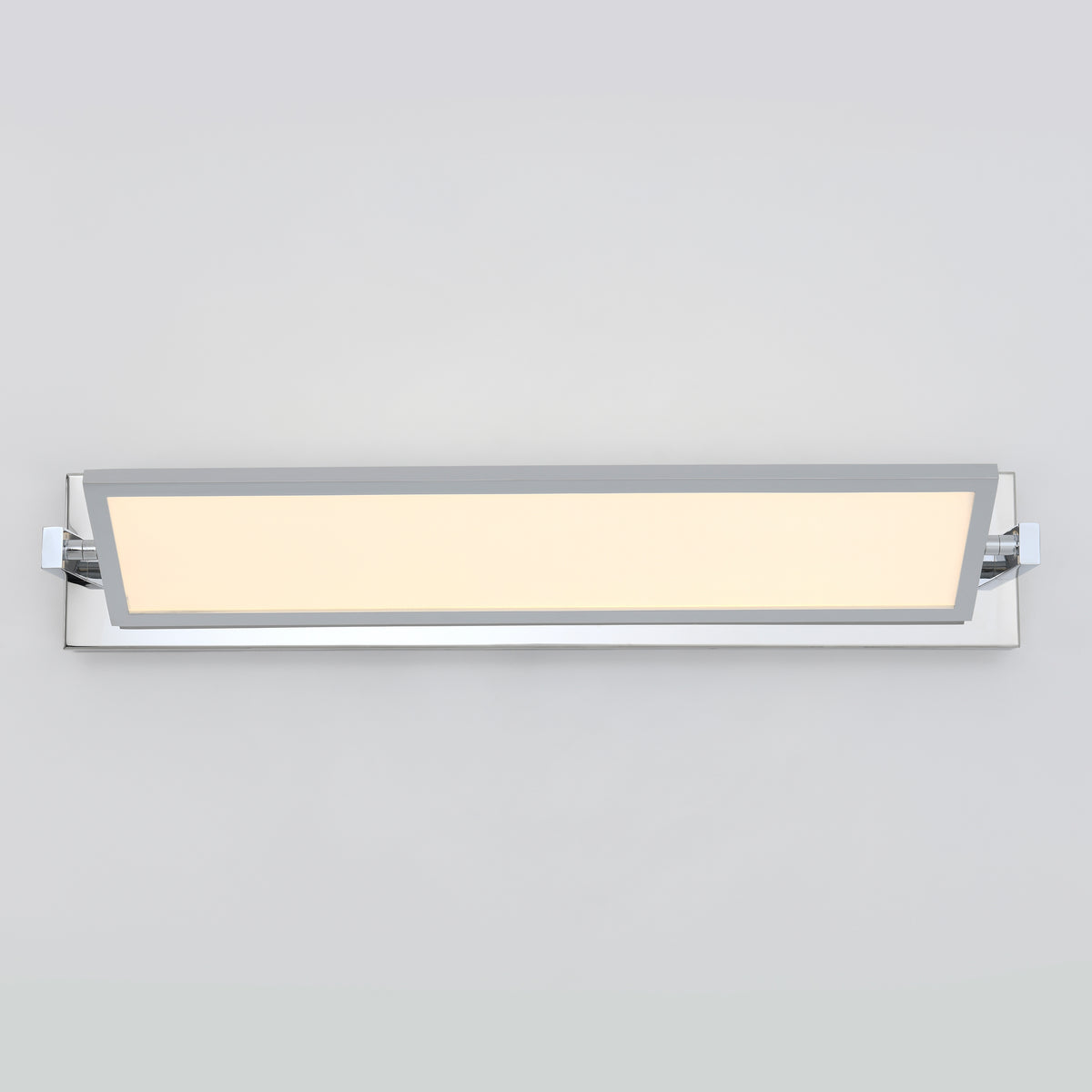 Rectangular modern wall-mounted LED light fixture with a frosted panel in the center, framed by a chrome trim, illuminated against a plain light gray background.