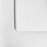 Close-up of a brushed metal surface next to a smooth, reflective glass or plastic panel with a rounded inner corner, creating a minimalistic and modern design contrast.