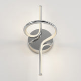 A modern wall sconce with a sleek, chrome finish featuring a circular base and a looping, curved light tube extending vertically, mounted on a plain white wall.
