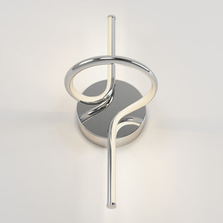 The Swirl LED Sconce by Artika features a circular base, metallic loop design, and an integrated LED light tube wrapping vertically through the center, all finished in sleek chrome.