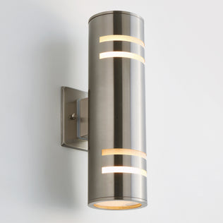 The Artika Voltz indoor-outdoor wall light features a modern cylindrical brushed metal design with horizontal cutouts, mounted on a square plate against a plain white background.
