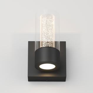 The Artika Essence 1-light LED vanity light features a cylindrical glass shade, black base, and dimmable accent lighting.
