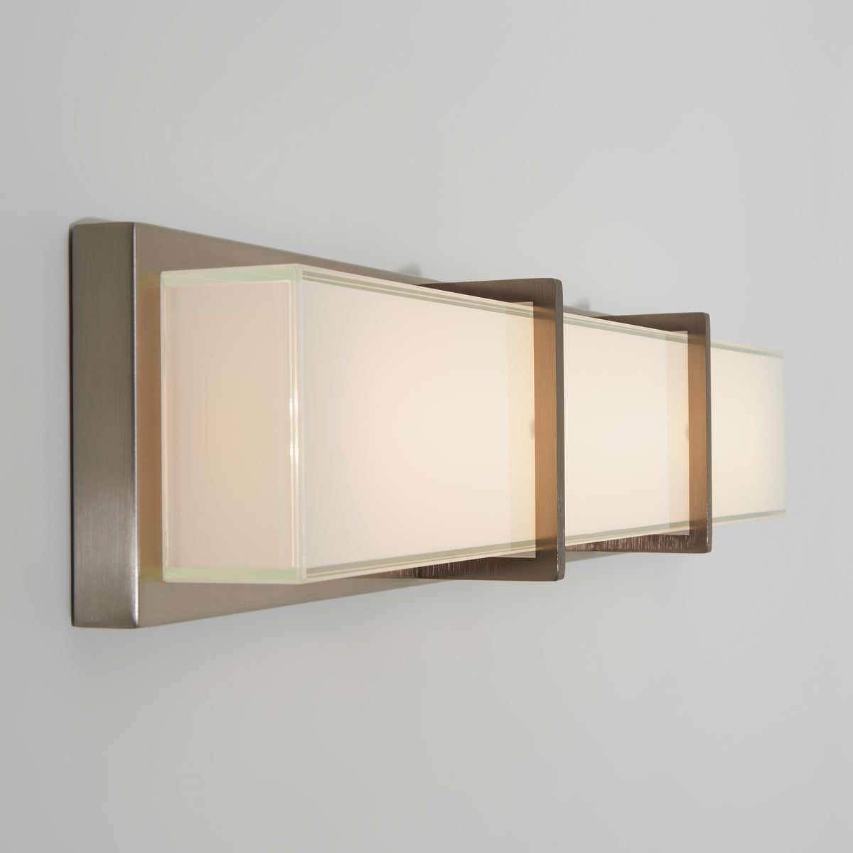 The Artika Subway modern LED bathroom vanity light features three frosted glass panels and a metallic base.