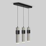 Three cylindrical pendant lights with concrete-grey finishes and black metal bands hang in a row from a rectangular black ceiling mount against a plain light grey background.