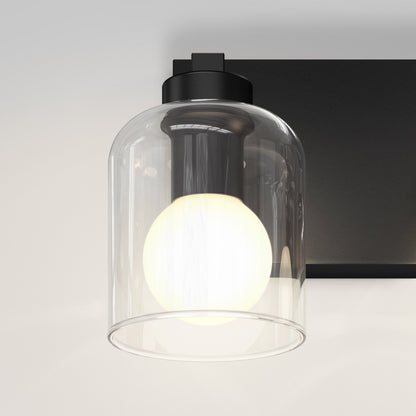 The Artika Aryna 20 in. 3-Light LED Vanity shines with clear glass shades on a black fixture, mounted on a white wall.