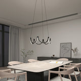A modern dining room with a rectangular table, six light wood chairs, a unique black chandelier, minimalist décor, a sideboard, abstract art, and a plant by a large window with sheer curtains.