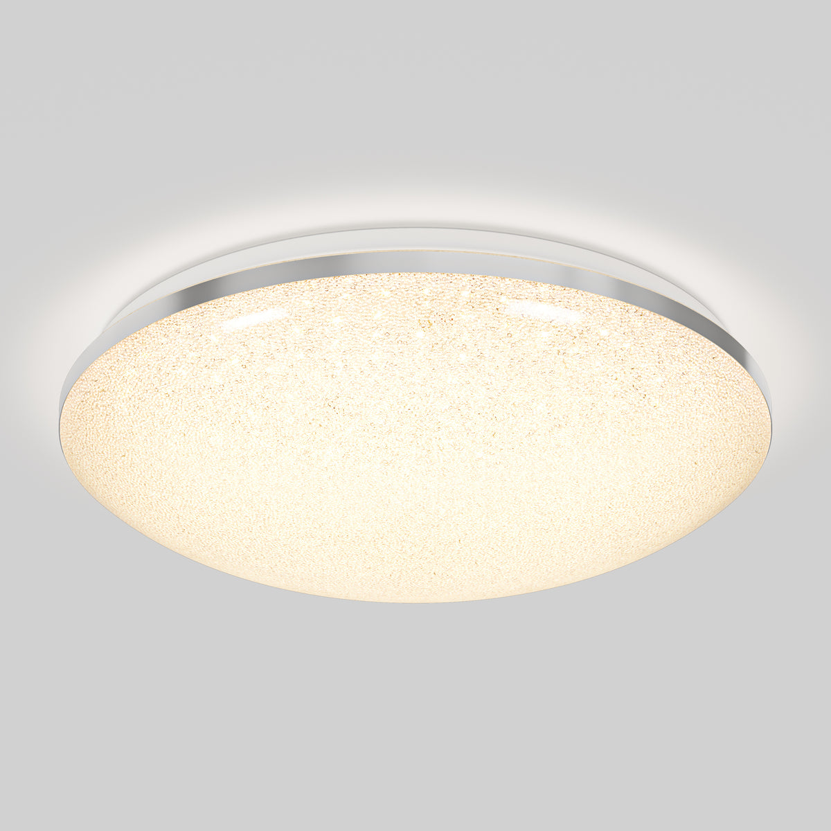 A round, flush-mounted ceiling light fixture with a textured, glowing white surface and a metallic rim, emitting soft, diffused light against a light gray background.