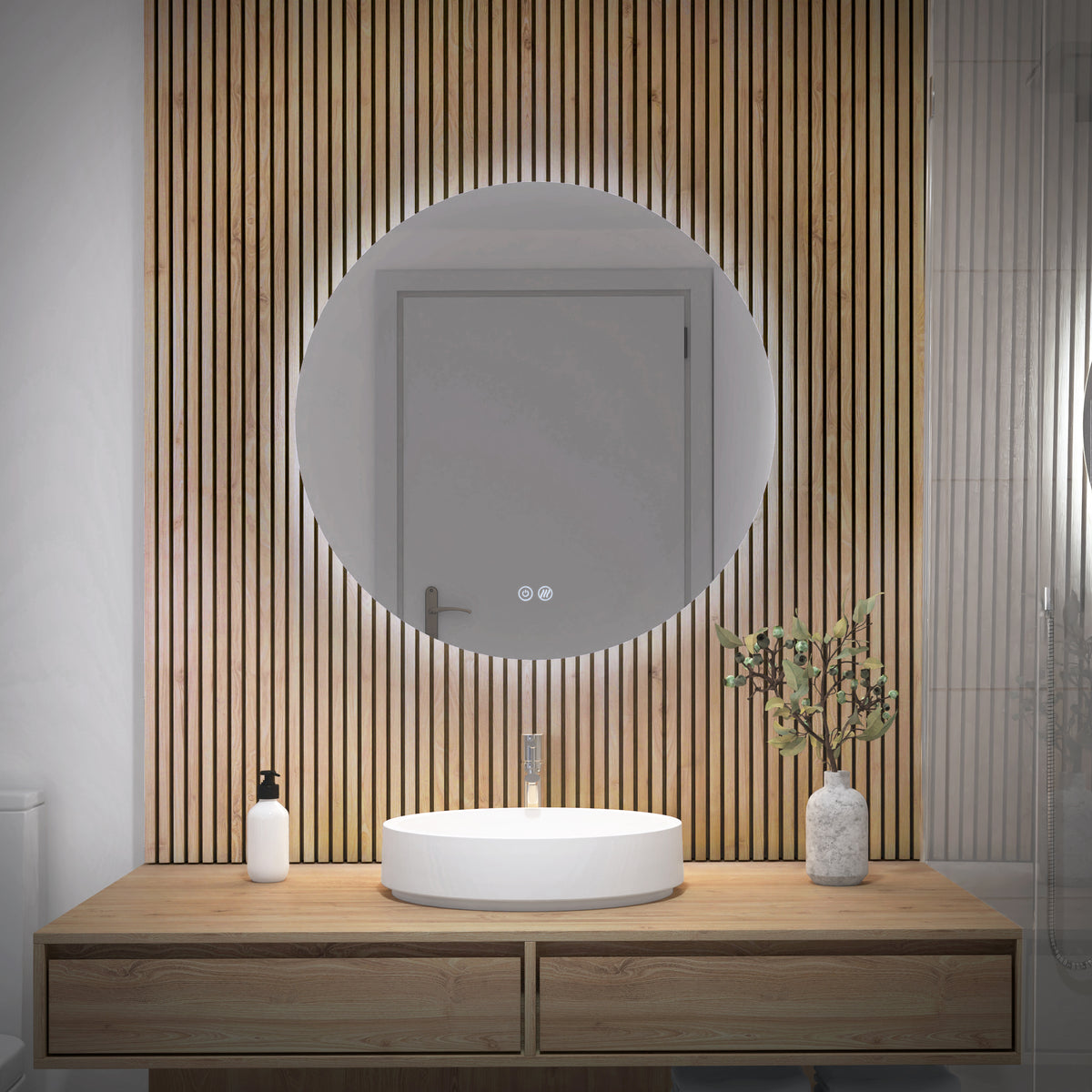 Modern bathroom with the Artika Raya 24 in. LED mirror (3 CCT, defogger) above a wooden vanity with vessel sink, soap dispenser, and greenery in a vase. Vertical wooden slats accent the wall behind the mirror.