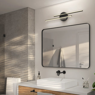 A modern bathroom features a textured concrete wall, square white sink, black-framed mirror, and the Artika Cisco 27-in Integrated LED 5-CCT Vanity Light Bar, which enhances the minimalist space as sunlight streams through blinds with striped shadows.