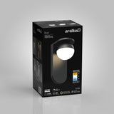 A black box packaging for an Artika Bloom LED wall light, featuring an image of the light fixture, product details, brightness, energy efficiency, and color temperature icons on a gray background.