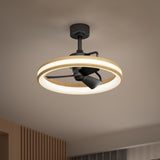 A modern ceiling fan with black blades and a circular LED light ring, mounted on a beige ceiling in a contemporary room with wooden and fabric accents visible below.